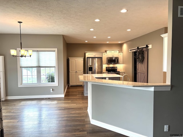 221 Briarwood Ln, Seward, NE 68434 - kitchen featuring appliances with stainless steel finishes, a barn door, a chandelier, recessed lighting, and dark wood-style flooring