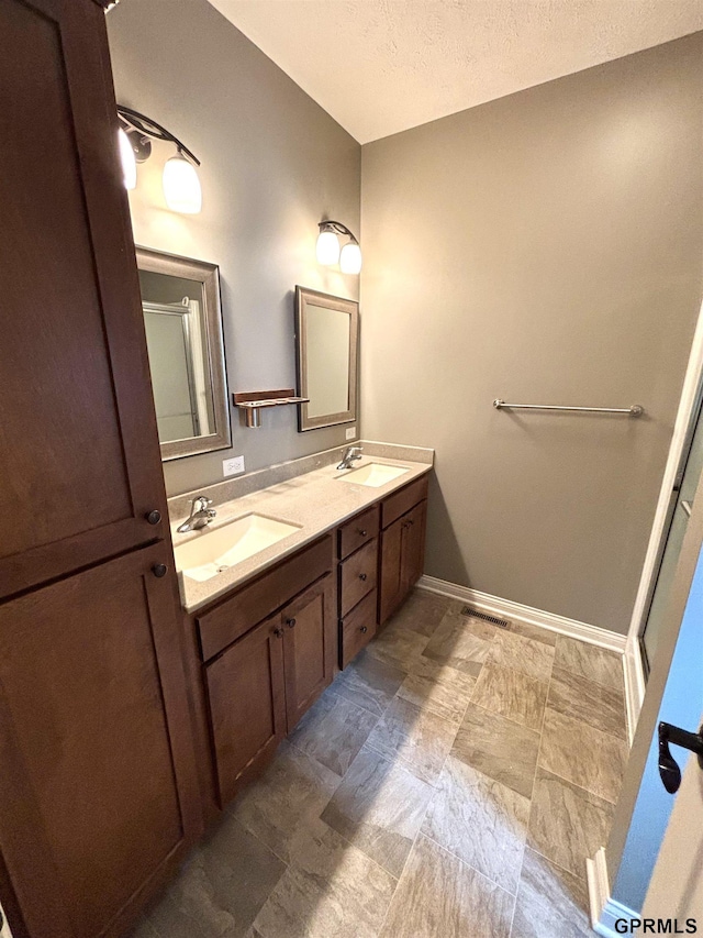 221 Briarwood Ln, Seward, NE 68434 - bathroom with double vanity, a textured ceiling, and baseboards