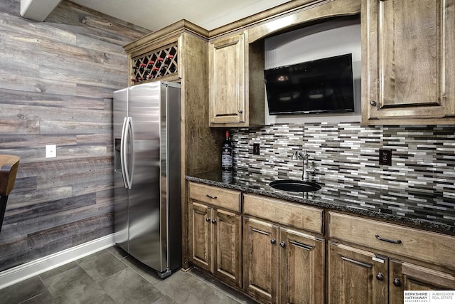 1809 S 220th Ave, Omaha, NE 68022 - kitchen featuring stainless steel fridge with ice dispenser, wood walls, tasteful backsplash, and dark stone counters