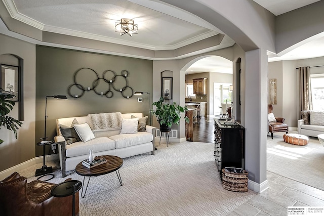 1809 S 220th Ave, Omaha, NE 68022 - living area with arched walkways, ornamental molding, light colored carpet, and a tray ceiling