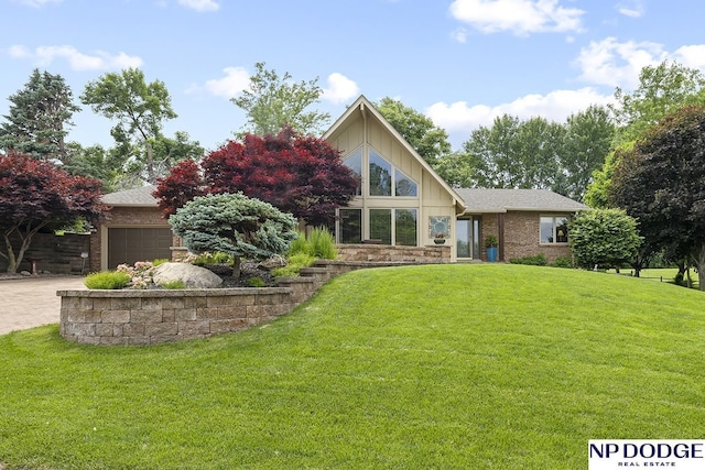 2723 Eagle Dr, Fremont, NE 68028 - mid-century modern home featuring a front lawn, an attached garage, brick siding, and roof with shingles