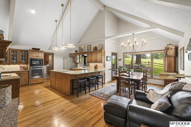 2723 Eagle Dr, Fremont, NE 68028 - living room featuring beam ceiling, a chandelier, high vaulted ceiling, and light wood-style flooring