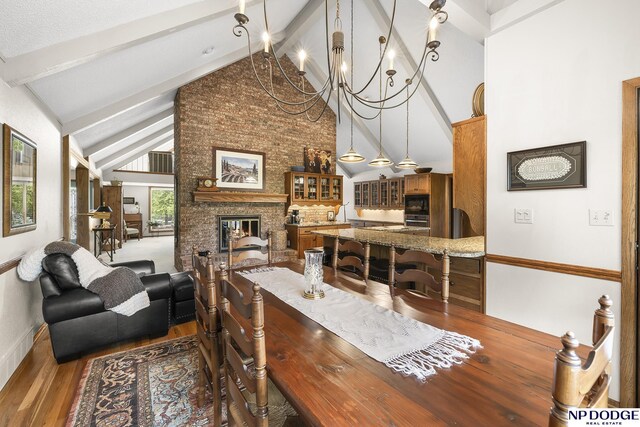 2723 Eagle Dr, Fremont, NE 68028 - dining area with beam ceiling, wood finished floors, a fireplace, high vaulted ceiling, and a chandelier