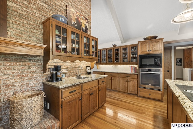 2723 Eagle Dr, Fremont, NE 68028 - kitchen featuring stainless steel oven, black microwave, a sink, light wood-style floors, and backsplash