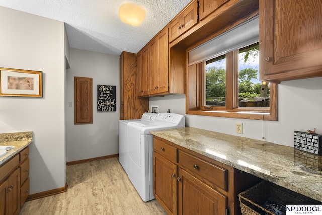 2723 Eagle Dr, Fremont, NE 68028 - laundry room featuring cabinet space, washing machine and dryer, light wood finished floors, baseboards, and a textured ceiling