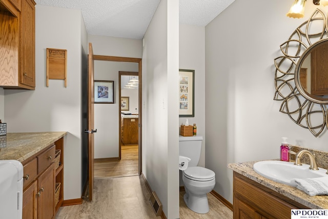 2723 Eagle Dr, Fremont, NE 68028 - bathroom featuring toilet, vanity, a textured ceiling, and baseboards