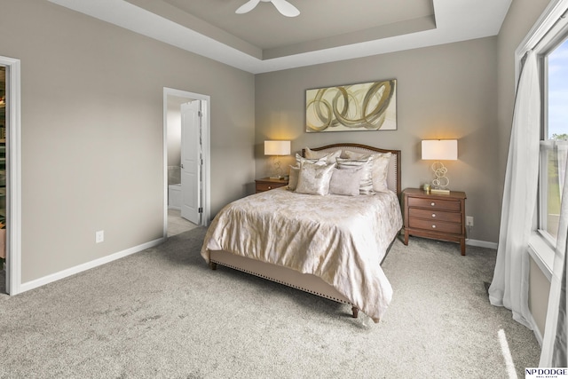 15301 Kansas Ave, Omaha, NE 68116 - carpeted bedroom featuring a tray ceiling, baseboards, ensuite bathroom, and ceiling fan