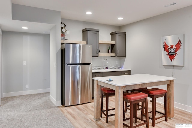 11511 S 190th St, Gretna, NE 68028 - kitchen with freestanding refrigerator, gray cabinets, light countertops, a sink, and a breakfast bar