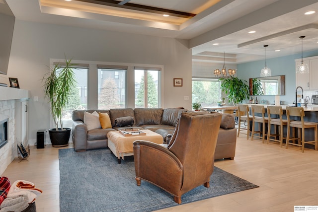 11511 S 190th St, Gretna, NE 68028 - living room with a raised ceiling, light wood-type flooring, recessed lighting, a glass covered fireplace, and a chandelier