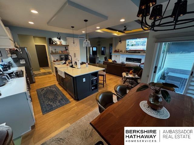 11511 S 190th St, Gretna, NE 68028 - kitchen featuring a tray ceiling, light countertops, open floor plan, light wood-type flooring, and recessed lighting