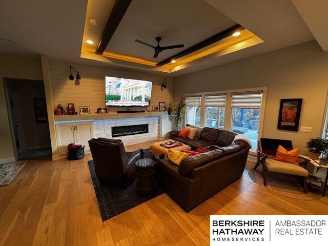 11511 S 190th St, Gretna, NE 68028 - living area featuring a ceiling fan, a fireplace, a raised ceiling, light wood-type flooring, and recessed lighting