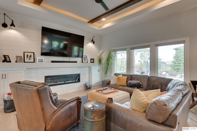 11511 S 190th St, Gretna, NE 68028 - living area with a tray ceiling, a stone fireplace, light wood finished floors, and wood walls