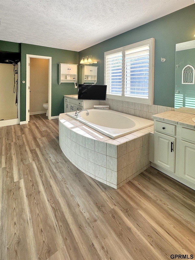 18063 Jones St, Elkhorn, NE 68022 - full bath featuring a bath, vanity, wood finished floors, and a textured ceiling