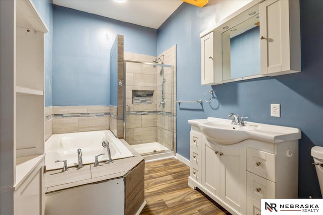 610 S 10th St, Plattsmouth, NE 68048 - bathroom with a stall shower, vanity, a bath, wood finished floors, and toilet