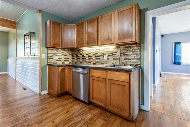 610 S 10th St, Plattsmouth, NE 68048 - kitchen with dishwasher, wood finished floors, a sink, and brown cabinets