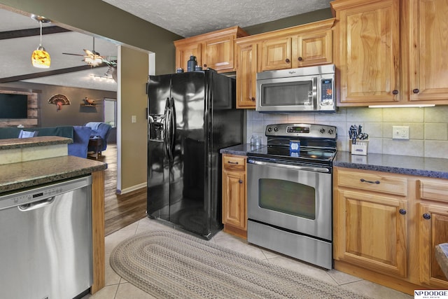 S-44 Poehling Ln, Fremont, NE 68025 - kitchen featuring stainless steel appliances, a ceiling fan, backsplash, open floor plan, and light tile patterned floors