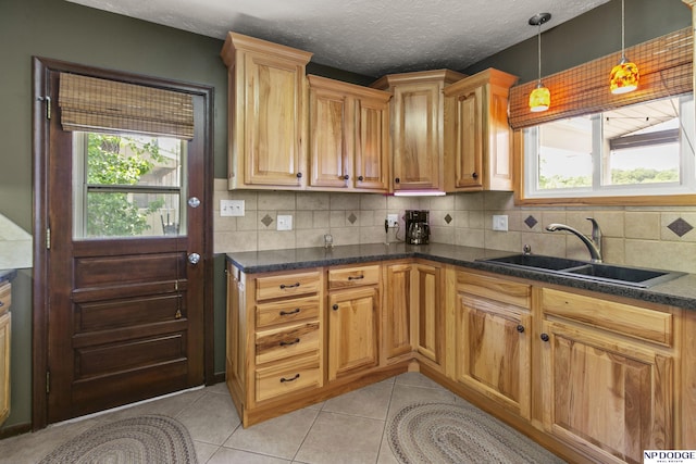 S-44 Poehling Ln, Fremont, NE 68025 - kitchen featuring a sink, backsplash, light tile patterned floors, pendant lighting, and a textured ceiling