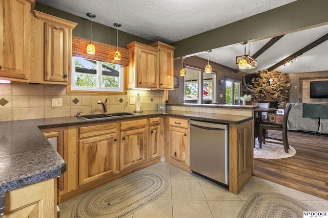 S-44 Poehling Ln, Fremont, NE 68025 - kitchen featuring dishwasher, a sink, dark countertops, a peninsula, and open floor plan