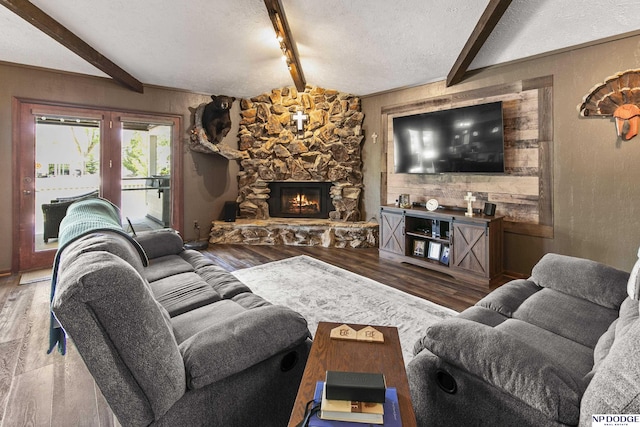 S-44 Poehling Ln, Fremont, NE 68025 - living room featuring beam ceiling, wood finished floors, a textured ceiling, a stone fireplace, and baseboards