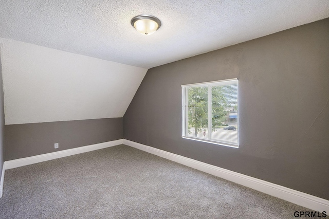 2945 N 59th St, Omaha, NE 68104 - additional living space featuring carpet floors, vaulted ceiling, a textured ceiling, and baseboards