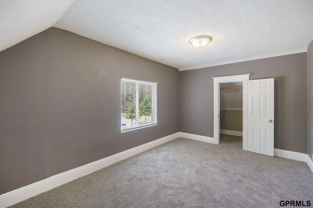2945 N 59th St, Omaha, NE 68104 - unfurnished bedroom with carpet floors, vaulted ceiling, a textured ceiling, a closet, and baseboards