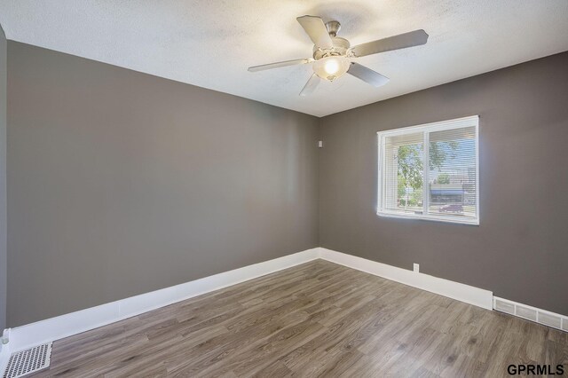 2945 N 59th St, Omaha, NE 68104 - unfurnished room with wood finished floors, ceiling fan, baseboards, and a textured ceiling