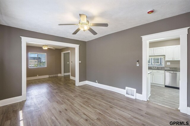 2945 N 59th St, Omaha, NE 68104 - unfurnished room featuring a ceiling fan, light wood-style flooring, baseboards, and a sink