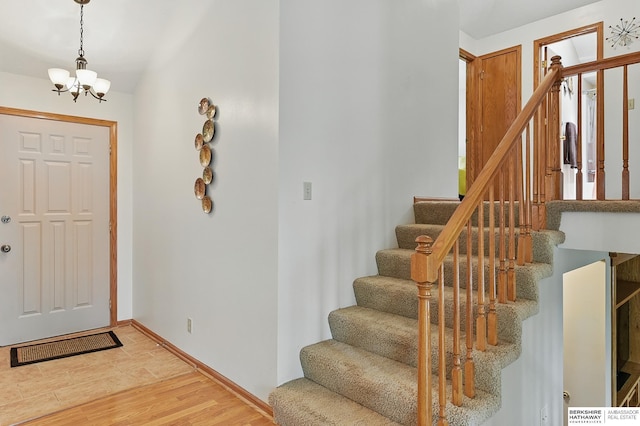 12335 Wirt St, Omaha, NE 68164 - foyer entrance featuring a chandelier, stairs, light wood finished floors, and baseboards
