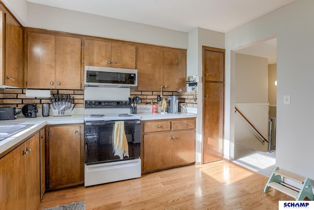 253 S 110th St, Omaha, NE 68154 - kitchen with white appliances, backsplash, light countertops, and brown cabinetry