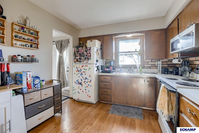 253 S 110th St, Omaha, NE 68154 - kitchen with white appliances, light wood finished floors, light countertops, decorative backsplash, and a sink