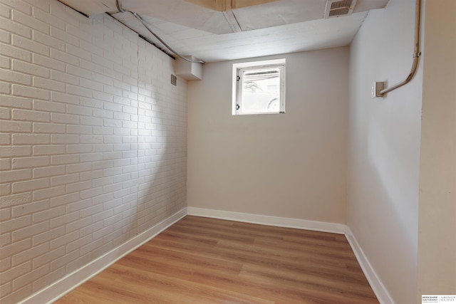 1444 S 16th St, Omaha, NE 68108 - unfurnished room with light wood-type flooring, baseboards, and brick wall