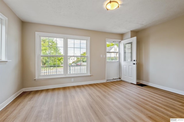 1444 S 16th St, Omaha, NE 68108 - entrance foyer with light wood-style flooring, healthy amount of natural light, baseboards, and a textured ceiling
