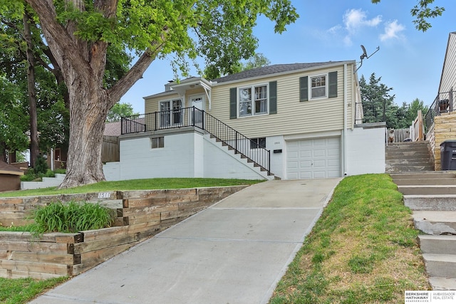 1511 S 60th St, Omaha, NE 68106 - view of front facade with stairs, an attached garage, concrete driveway, and a front yard