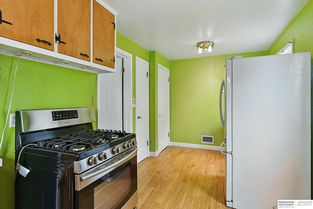 1511 S 60th St, Omaha, NE 68106 - kitchen featuring freestanding refrigerator, stainless steel range with gas stovetop, light wood-type flooring, baseboards, and brown cabinetry