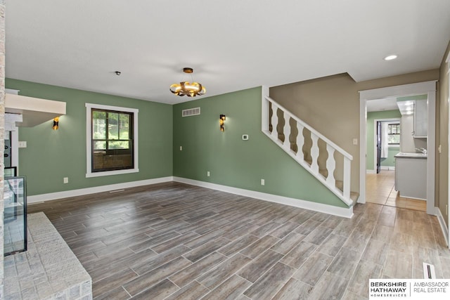 17409 Webster Blvd, Plattsmouth, NE 68048 - unfurnished living room with stairway, baseboards, wood finished floors, a chandelier, and recessed lighting