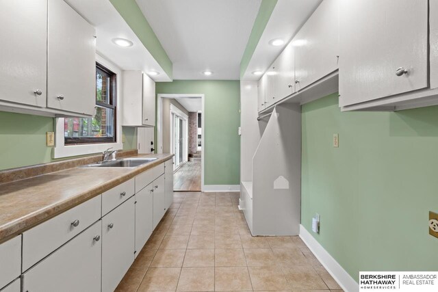 17409 Webster Blvd, Plattsmouth, NE 68048 - kitchen featuring a sink, recessed lighting, white cabinets, light tile patterned floors, and baseboards