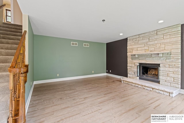 17409 Webster Blvd, Plattsmouth, NE 68048 - unfurnished living room with wood finished floors, stairway, baseboards, a fireplace, and recessed lighting