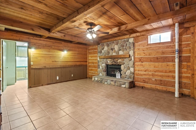17409 Webster Blvd, Plattsmouth, NE 68048 - unfurnished living room with wood ceiling with exposed beams, wood walls, a ceiling fan, tile patterned flooring, and a stone fireplace