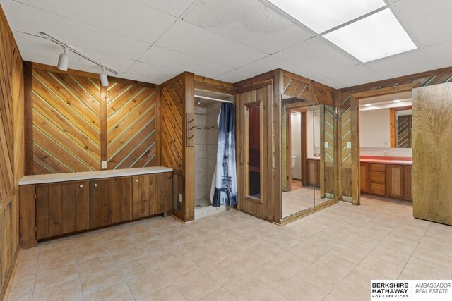 17409 Webster Blvd, Plattsmouth, NE 68048 - empty room featuring rail lighting, wood walls, and bar