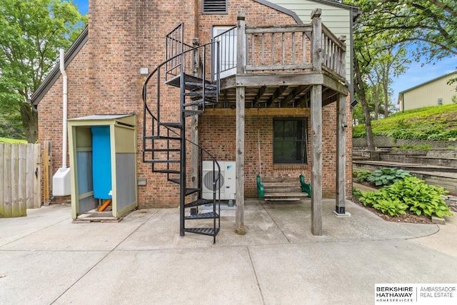 17409 Webster Blvd, Plattsmouth, NE 68048 - rear view of house featuring stairway, brick siding, ac unit, and a patio area