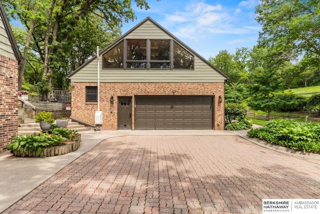 17409 Webster Blvd, Plattsmouth, NE 68048 - view of front of house with an attached garage, brick siding, driveway, and stairs