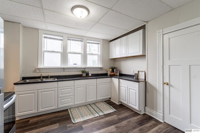 4328 Burdette St, Omaha, NE 68111 - kitchen featuring a sink, electric range, dark countertops, white cabinetry, and a drop ceiling