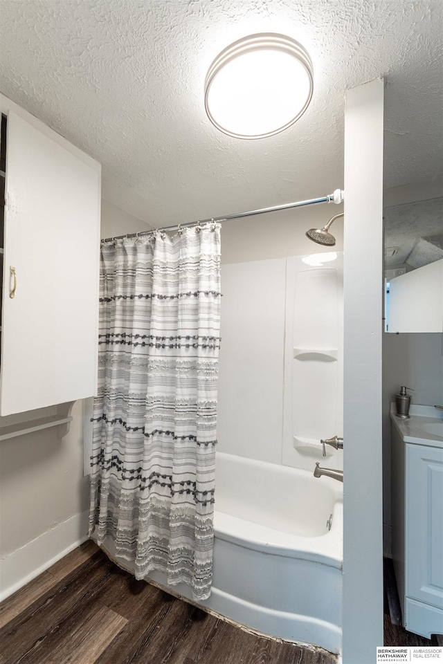4328 Burdette St, Omaha, NE 68111 - bathroom featuring wood finished floors, shower / bathtub combination with curtain, a textured ceiling, and baseboards
