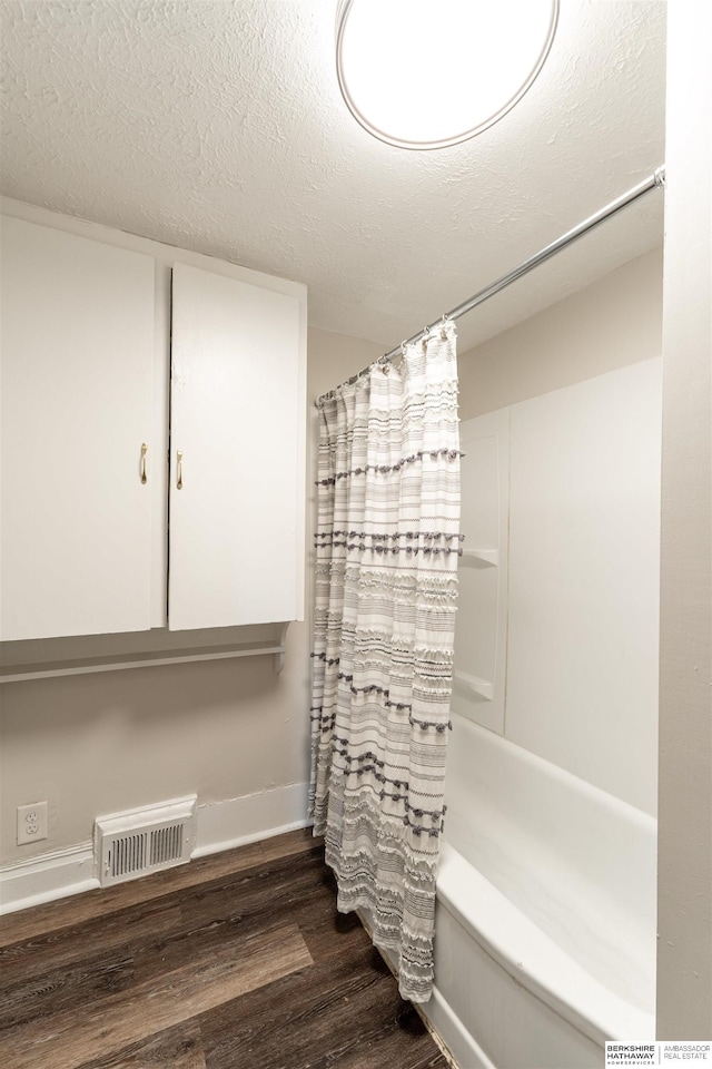 4328 Burdette St, Omaha, NE 68111 - bathroom with wood finished floors, shower / bath combination with curtain, and a textured ceiling