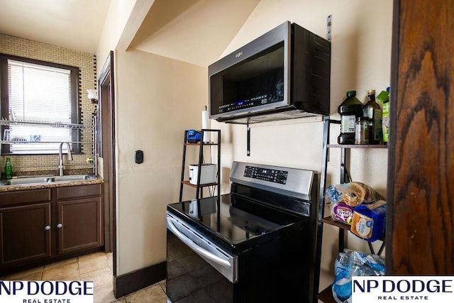 4023 Maple St, Omaha, NE 68111 - kitchen with appliances with stainless steel finishes, a sink, light tile patterned floors, and dark brown cabinetry