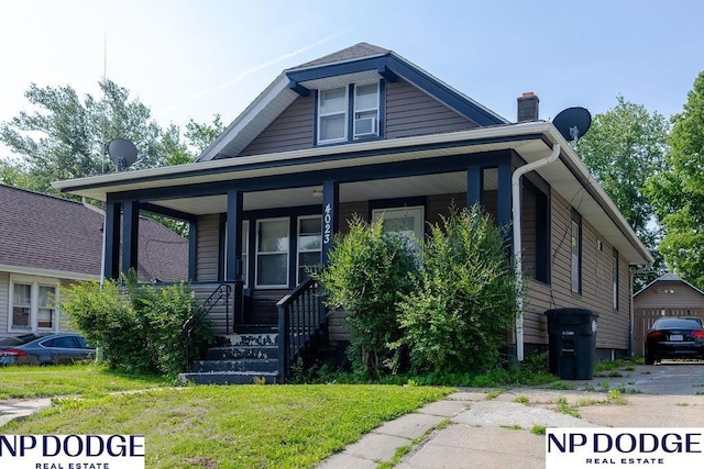 4023 Maple St, Omaha, NE 68111 - bungalow-style house with covered porch, a chimney, and a front lawn