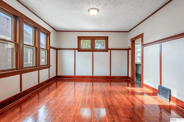 620 Dorcas St, Omaha, NE 68108 - unfurnished room with wood-type flooring, crown molding, a textured ceiling, and baseboards