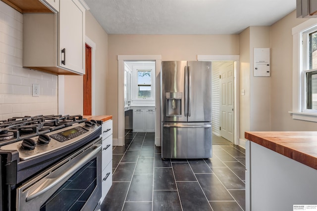 620 Dorcas St, Omaha, NE 68108 - kitchen with appliances with stainless steel finishes, wooden counters, backsplash, and white cabinets