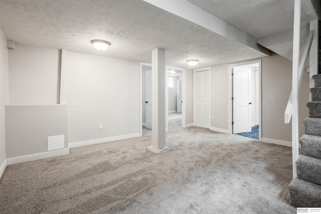 620 Dorcas St, Omaha, NE 68108 - finished below grade area with stairway, a textured ceiling, carpet, and baseboards