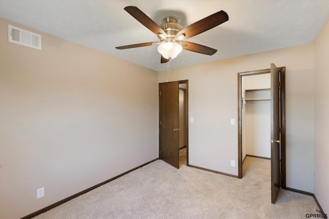 12749 Woodcrest Plz Unit 211B, Omaha, NE 68137 - unfurnished bedroom with a walk in closet, baseboards, light colored carpet, a closet, and a ceiling fan